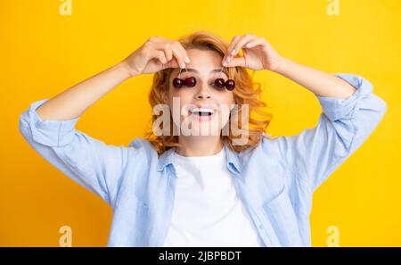 Porträt der Schönheit rötete Frau mit Kirschen auf gelb isolierten Hintergrund. Stockfoto