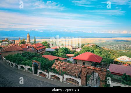 Blick auf Sighnaghi in der Weinbauregion von Georgien, Kacheti, bei Sonnenuntergang im Sommer mit Kaukasus-Bergen im Hintergrund Stockfoto