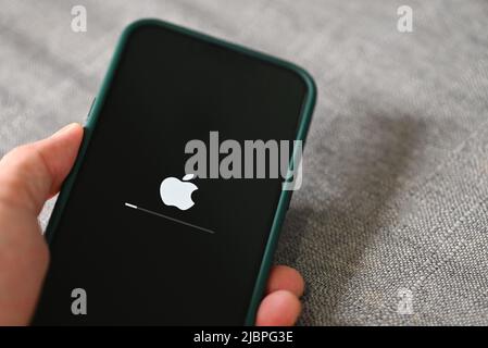 IPhone 13 Pro mit Apple-Logo laden und installieren Betriebssystem ios 15,5 auf dem Bildschirm Nahaufnahme, neue ios 2022 auf Apple-Geräten Sub v. ios 15 für Stockfoto