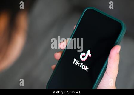 Kind hält Smartphone mit TikTok-Anwendungssymbol auf dem Apple iPhone 13 Pro, TikTok-Logo-Symbol auf dem Bildschirm beliebte Social-Media-Netzwerk aus china, Stockfoto