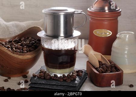 Wiener Kaffee oder Vietnam Drip mit Kaffeebohne auf rustikalem Retro-Tisch Stockfoto