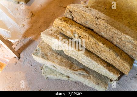 Auf dem Boden liegen Reste der Mineralwolldämmplatte Stockfoto