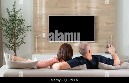Rückansicht Paar auf Sofa im Wohnzimmer liegen Stockfoto