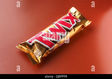 Twix Schokoladenriegel auf orangefarbenem Hintergrund, weicher Fokus. Stockfoto