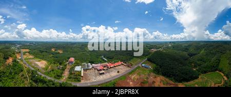 Luftpanorama der National Route 14 in der Provinz Binh Phuoc, Vietnam mit hügeliger Landschaft und spärlicher Bevölkerung rund um die Straßen. Reisen und landen Stockfoto