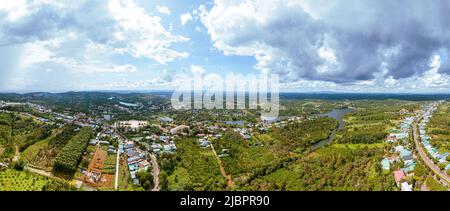 Luftpanorama der National Route 14 in Kien Duc Stadt, DAC Nong Provinz, Vietnam mit hügeliger Landschaft, spärlicher Bevölkerung rund um die Straßen und Da Stockfoto