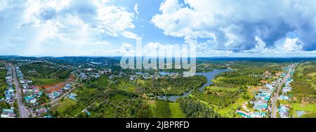 Luftpanorama der National Route 14 in Kien Duc Stadt, DAC Nong Provinz, Vietnam mit hügeliger Landschaft, spärlicher Bevölkerung rund um die Straßen und Da Stockfoto