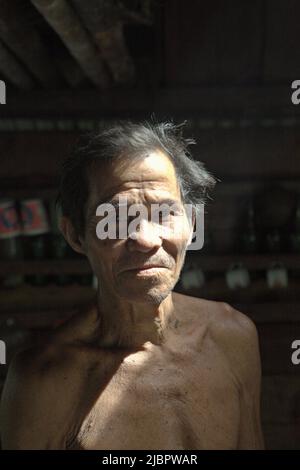 Porträt von Daniel Rajang, ehemaliger Tumenggung (traditioneller Häuptling) der Gemeinde Orung da'an Dayak, in seiner Bauernhütte im Dorf Nanga Raun, Kalis, Kapuas Hulu, West Kalimantan, Indonesien. Die Orung da'an-Gemeinde besaß einst das längste Langhaus in Kalimantan, aber es verschwand nach einem Feuerunfall vor ein paar Jahrzehnten, sagte er. Stockfoto