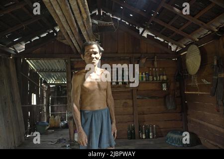 Porträt von Daniel Rajang, ehemaliger Tumenggung (traditioneller Häuptling) der Gemeinde Orung da'an Dayak, in seiner Bauernhütte im Dorf Nanga Raun, Kalis, Kapuas Hulu, West Kalimantan, Indonesien. Die Orung da'an-Gemeinde besaß einst das längste Langhaus in Kalimantan, aber es verschwand nach einem Feuerunfall vor ein paar Jahrzehnten, sagte er. Stockfoto