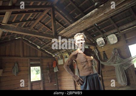 Porträt von Daniel Rajang, ehemaliger Tumenggung (traditioneller Häuptling) der Gemeinde Orung da'an Dayak, in seiner Bauernhütte im Dorf Nanga Raun, Kalis, Kapuas Hulu, West Kalimantan, Indonesien. Die Orung da'an-Gemeinde besaß einst das längste Langhaus in Kalimantan, aber es verschwand nach einem Feuerunfall vor ein paar Jahrzehnten, sagte er. Stockfoto