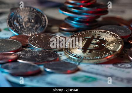 Goldbitcoin neben Dollarmünzen und Banknoten. US-Dollar-Bargeld stapelte Münzen und Papiergeld als Hintergrund auf. Krypto-Währung und Blockchain-Technologie Stockfoto