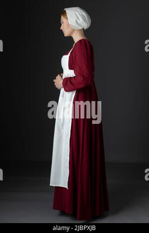 Ein Regency Dienstmädchen, das ein rotes Kleid und eine Schürze trägt Stockfoto