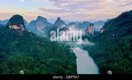 (220608) -- WUYISHAN, 8. Juni 2022 (Xinhua) -- Luftfoto vom 7. Juni 2022 zeigt die Landschaft des Berges Wuyi in der südöstlichen Provinz Fujian in China. Der Berg Wuyi, der sich in der südöstlichen Provinz Fujian Chinas befindet, ist eine Landschaft von großer Schönheit, in der die Gipfel und Felsen grotesker Formen von klaren Bächen umgürtet und von grünen Bäumen und Bambuspflanzen umarmt werden. Als Lebensraum für eine große Anzahl von Wildtieren ist es von enormer Bedeutung für den Erhalt der biologischen Vielfalt. Auf dem Berg Wuyi gibt es eine Reihe außergewöhnlicher archäologischer Stätten, darunter die Überreste der alten Han-Dynastie ( Stockfoto