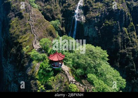 (220608) -- WUYISHAN, 8. Juni 2022 (Xinhua) -- Luftfoto vom 6. Juni 2022 zeigt Touristen, die den Berg Wuyi in der südöstlichen Provinz Fujian in China besuchen. Der Berg Wuyi, der sich in der südöstlichen Provinz Fujian Chinas befindet, ist eine Landschaft von großer Schönheit, in der die Gipfel und Felsen grotesker Formen von klaren Bächen umgürtet und von grünen Bäumen und Bambuspflanzen umarmt werden. Als Lebensraum für eine große Anzahl von Wildtieren ist es von enormer Bedeutung für den Erhalt der biologischen Vielfalt. Auf dem Berg Wuyi gibt es eine Reihe außergewöhnlicher archäologischer Stätten, darunter die Überreste des alten Han-Dynast Stockfoto