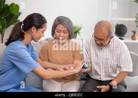 Eine Krankenschwester gibt dem Senior beim pensionierten Hausdienst eine Arznei. Stockfoto