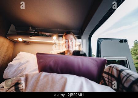 Junge Frau mit Laptop im Wohnmobil Stockfoto