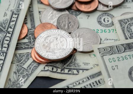 Half-Dollar-Münze auf kleineren Münzen, umgeben von Dollar-Banknoten. US-Wirtschaft und Währung. Bargeldzahlungen in die Höhe gestapelt Stockfoto