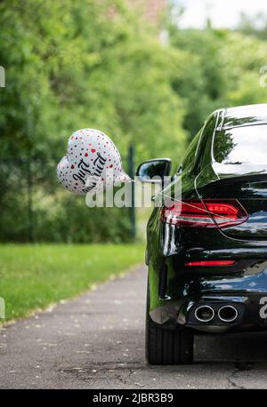 Rottweil, Deutschland. 04.. Juni 2022. Vor der Kirche ist ein Ballon in Herzform mit der Inschrift Just Married an einem Brautwagen befestigt. Kredit: Silas Stein/dpa/Alamy Live Nachrichten Stockfoto