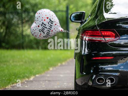 Rottweil, Deutschland. 04.. Juni 2022. Vor der Kirche ist ein Ballon in Herzform mit der Inschrift Just Married an einem Brautwagen befestigt. Kredit: Silas Stein/dpa/Alamy Live Nachrichten Stockfoto