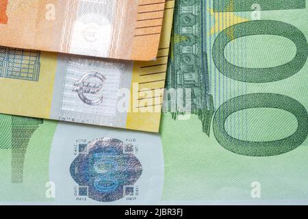 Bunte Euro-Banknote, Orange 50 Euro, Gelb 200 Euro und grüne 100 Euro-Scheine. Nahaufnahme der Euro-Rechnungen. Hologramm Reflecting Light Stockfoto