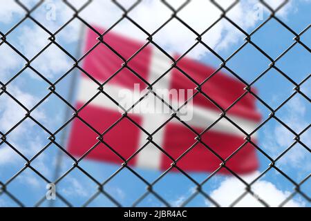 Ein Stahlgeflecht vor dem Hintergrund eines blauen Himmels und einem Fahnenmast mit der Flagge dänemarks Stockfoto