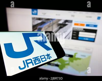 Handy mit Logo der japanischen Firma West Japan Railway (JR) auf dem Bildschirm vor der Business-Website. Konzentrieren Sie sich auf die linke Seite des Telefondisplays. Stockfoto