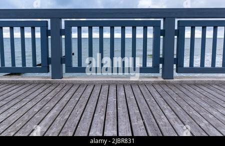 Seemandag mit Geländern. Holzpromenade zum Spazierengehen am Ufer entlang. Meerblick vom Küstendamm Stockfoto