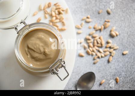 Sonnenblumenkerne Butter im Glas auf grauem Hintergrund. Stockfoto
