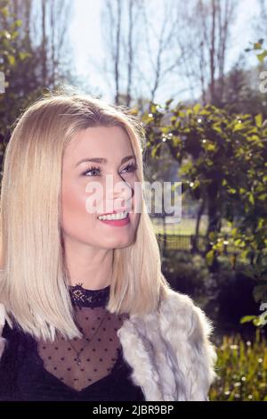 Porträt einer eleganten blonden Frau in einem Park Stockfoto