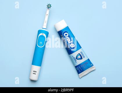 Elektrische Zahnbürste Oral-B Vitality und Oral B Zahnpasta auf blauem Hintergrund Stockfoto