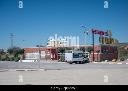 Das Café und Restaurant La Chamorra an einer Tankstelle in Nordspanien in Europa mit blauem Himmel und bunten Schildern. Stockfoto