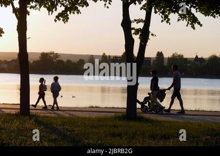 IVANO-FRANKIVSK, UKRAINE - 07. JUNI 2022 - am Abend wandern die Menschen am Kai des Stadtsees entlang, Ivano-Frankivsk, Westukraine. Dieses Foto kann nicht in der russischen Föderation verteilt werden. Stockfoto