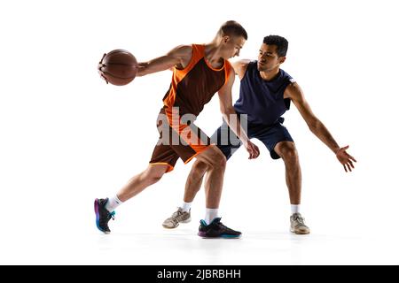 Porträt von zwei jungen professionellen Basketballspieler in Bewegung, Training isoliert auf weißem Studio-Hintergrund. Position des Verteidigers Stockfoto