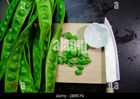 Frische parkia speciosa mit Samen- und Hühnermesser auf Schneidemoster Stockfoto