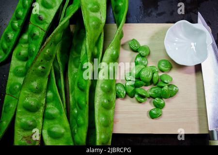 Frische parkia speciosa mit Samen- und Hühnermesser auf Schneidemoster Stockfoto