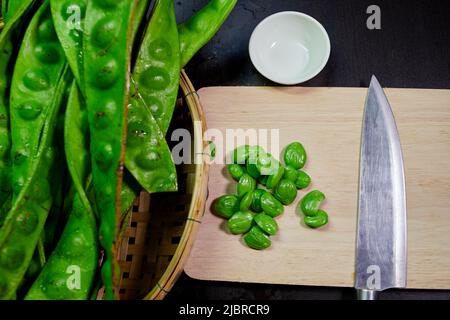 Frische parkia speciosa mit Samen- und Hühnermesser auf Schneidemoster Stockfoto