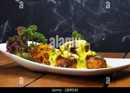 Heiße, kitschige Maisbällchen, serviert in weißer Schale, aus nächster Nähe Stockfoto