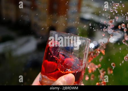 Ein Glas mit einem Getränk und spritzt herum. Hochwertige Fotos Stockfoto