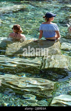 Pamukkale, Türkei, April 25. 2020 ausländische Touristen genießen die heilenden Eigenschaften des Thermalwassers unter umgestürzten römischen Säulen in Kleopatras Antique Stockfoto