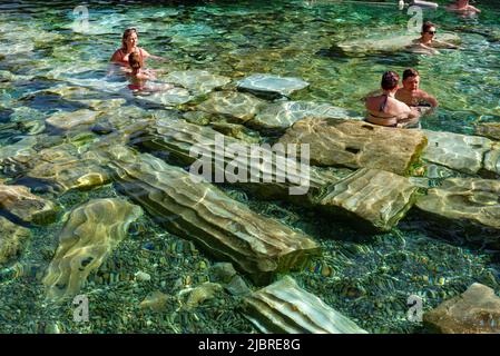 Pamukkale, Türkei, April 25. 2020 ausländische Touristen genießen die heilenden Eigenschaften des Thermalwassers unter umgestürzten römischen Säulen in Kleopatras Antique Stockfoto