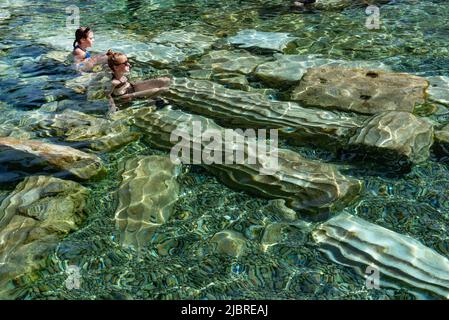 Pamukkale, Türkei, April 25. 2020 ausländische Touristen genießen die heilenden Eigenschaften des Thermalwassers unter umgestürzten römischen Säulen in Kleopatras Antique Stockfoto