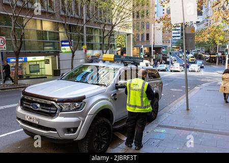 Sydney Stadtzentrum, council Ranger offiziellen stellt Parkschein zu illegal geparkten ford Ranger in Sydney, NSW, Australien Stockfoto