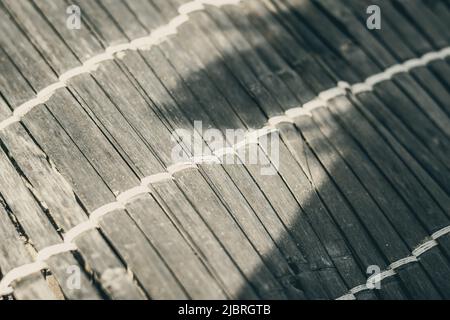 Alte gewebte Bambusdecke, raue Textur schmutzig, Fragment Banner. Diagonale horizontale vertikale Linien, Kontrastschatten. Platz für Text kopieren. Zusammenfassung Stockfoto