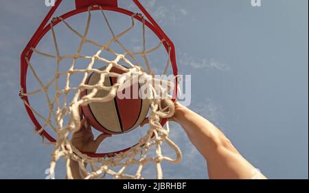 Mann dunking Basketball durch Netzring mit Händen, Sport Stockfoto