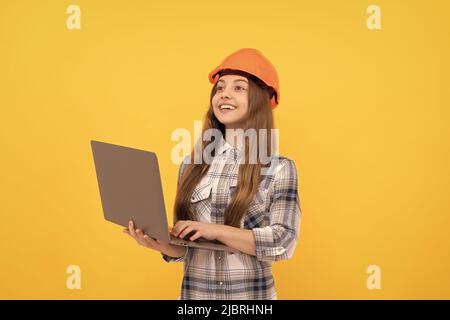 Happy teen Mädchen in Helm und karierte Hemd mit Laptop, Schule Stockfoto