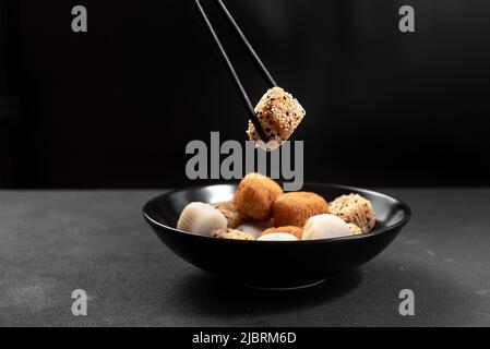 Teller mit japanischem Dessert verschiedener Art auf dunklem Hintergrund. Stockfoto