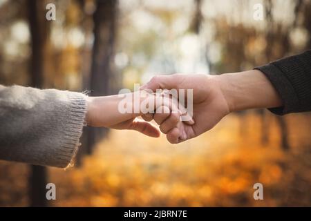 Nahaufnahme eines verliebten Paares, das beim Gehen die Hände hält. Selektiver Fokus Stockfoto