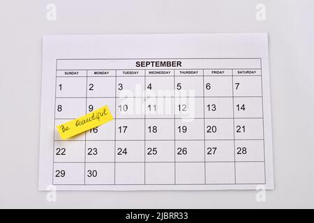 Sei schön handschriftlich auf dem Papier september Kalender. Isoliert auf weißem Hintergrund. Stockfoto