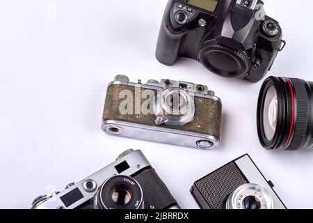Viele verschiedene Retro-Fotokameras auf weißem Hintergrund. Altmodische Kameras aus der Nähe. Stockfoto
