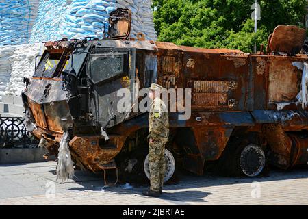 Kiew, Ukraine. 07.. Juni 2022. Ukrainischer Militärangehöriger untersucht zerstörte russische KAMAZ im Zentrum von Kiew. In der ukrainischen Hauptstadt wird eine Ausstellung verbrannter russischer Panzer und anderer gepanzerter Fahrzeuge fortgesetzt, um die Aufmerksamkeit auf den Krieg in anderen Teilen des Landes zu lenken. Kredit: SOPA Images Limited/Alamy Live Nachrichten Stockfoto